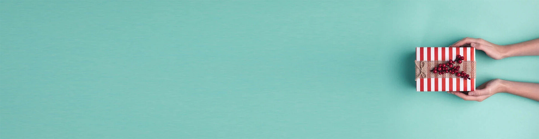 Two hands holding a red and white striped box on a blue background.