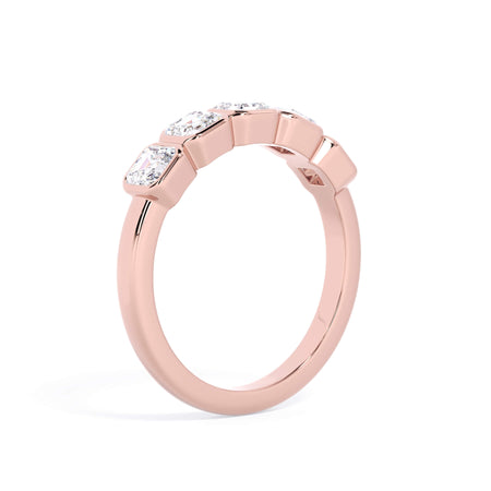 A picture of a five stone diamond wedding ring with asscher shape diamonds that are bezel set in rose gold on a white background with a slightly angled, through the finger view.