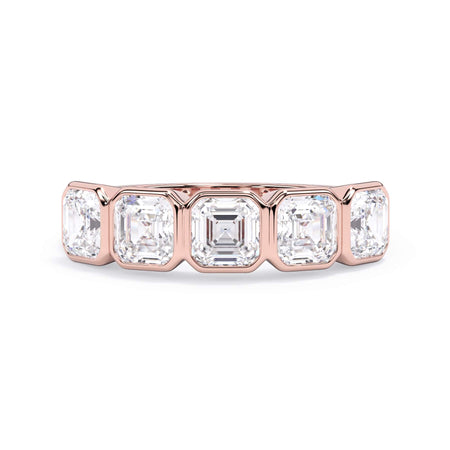 A picture of a five stone diamond wedding ring with asscher shape diamonds that are bezel set in rose gold on a white background with the ring facing forward, lying down.
