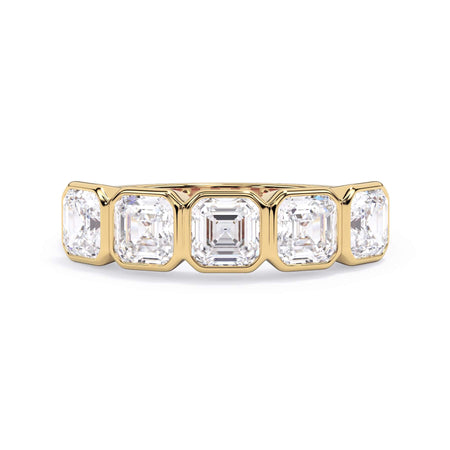 A picture of a five stone diamond wedding ring with asscher shape diamonds that are bezel set in yellow gold on a white background with the ring facing forward, lying down.