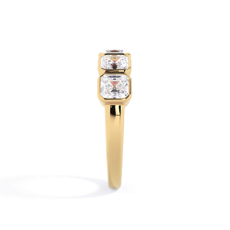 A picture of a five stone diamond wedding ring with asscher shape diamonds that are bezel set in yellow gold on a white background with a side profile view.