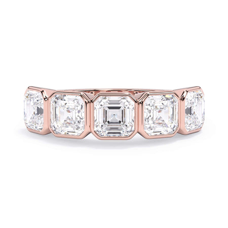 A picture of a five stone diamond wedding ring with asscher shape diamonds that are bezel set in rose gold on a white background with the ring facing forward, lying down.