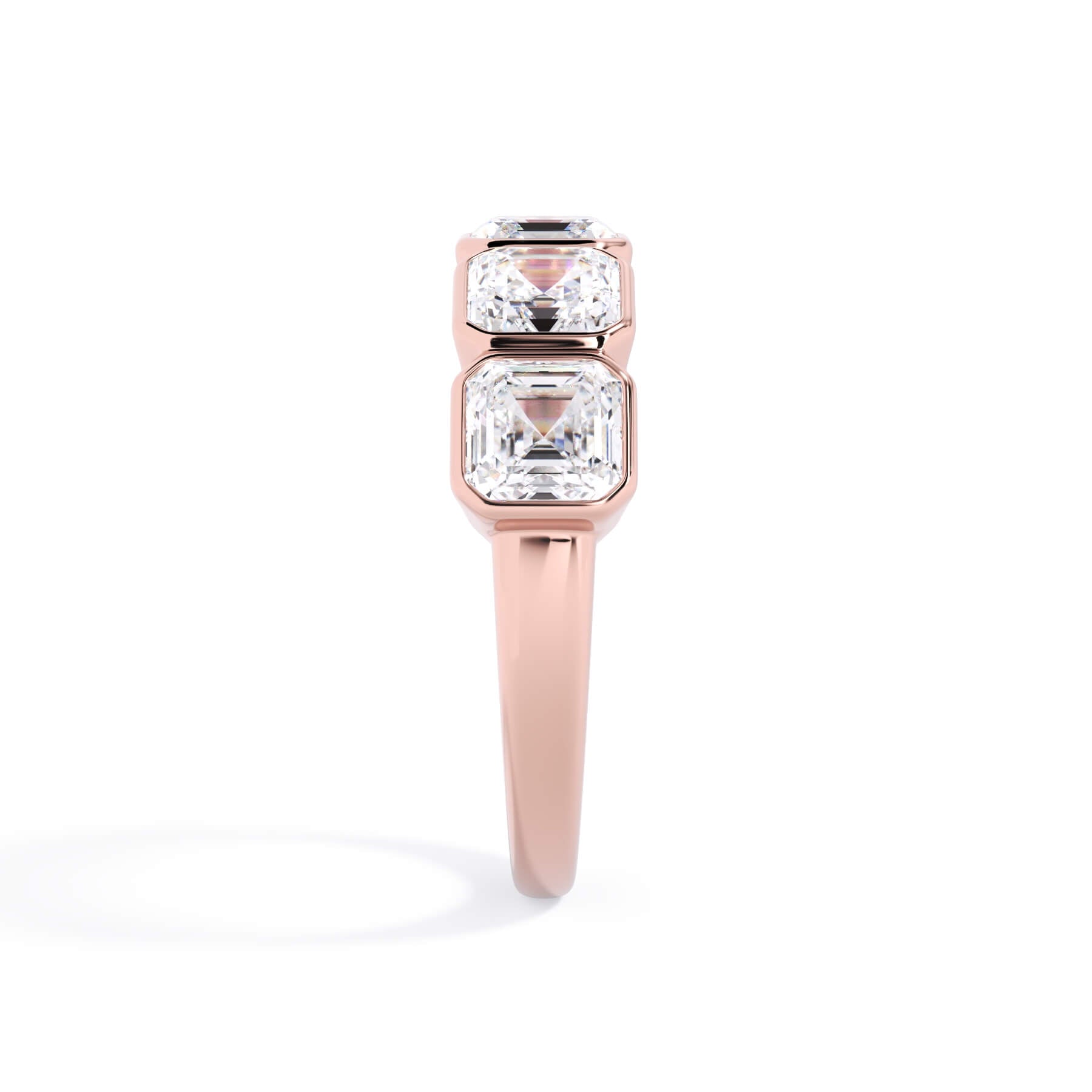 A picture of a five stone diamond wedding ring with asscher shape diamonds that are bezel set in rose gold on a white background with a side profile view.