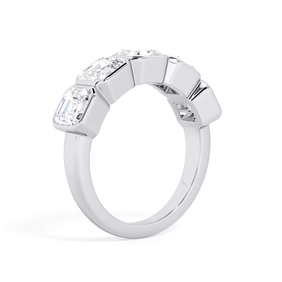 A picture of a five stone diamond wedding ring with asscher shape diamonds that are bezel set in white gold or platinum on a white background with a slightly angled, through the finger view.