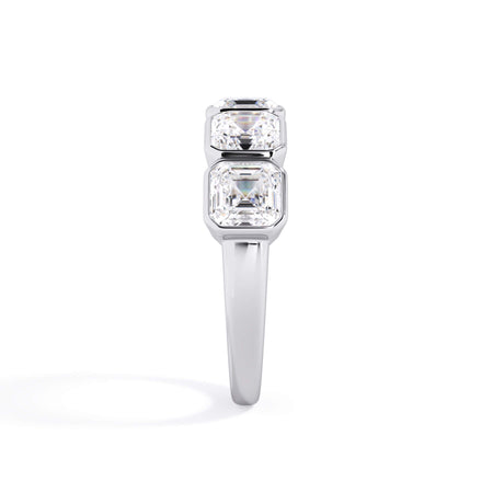 A picture of a five stone diamond wedding ring with asscher shape diamonds that are bezel set in white gold or platinum on a white background with a side profile view.