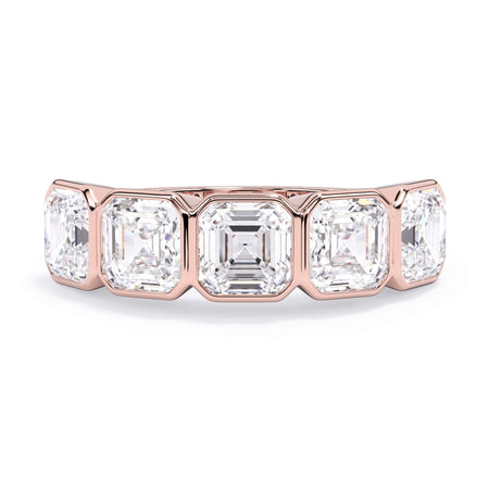 A picture of a five stone diamond wedding ring with asscher shape diamonds that are bezel set in rose gold on a white background with the ring facing forward, lying down.