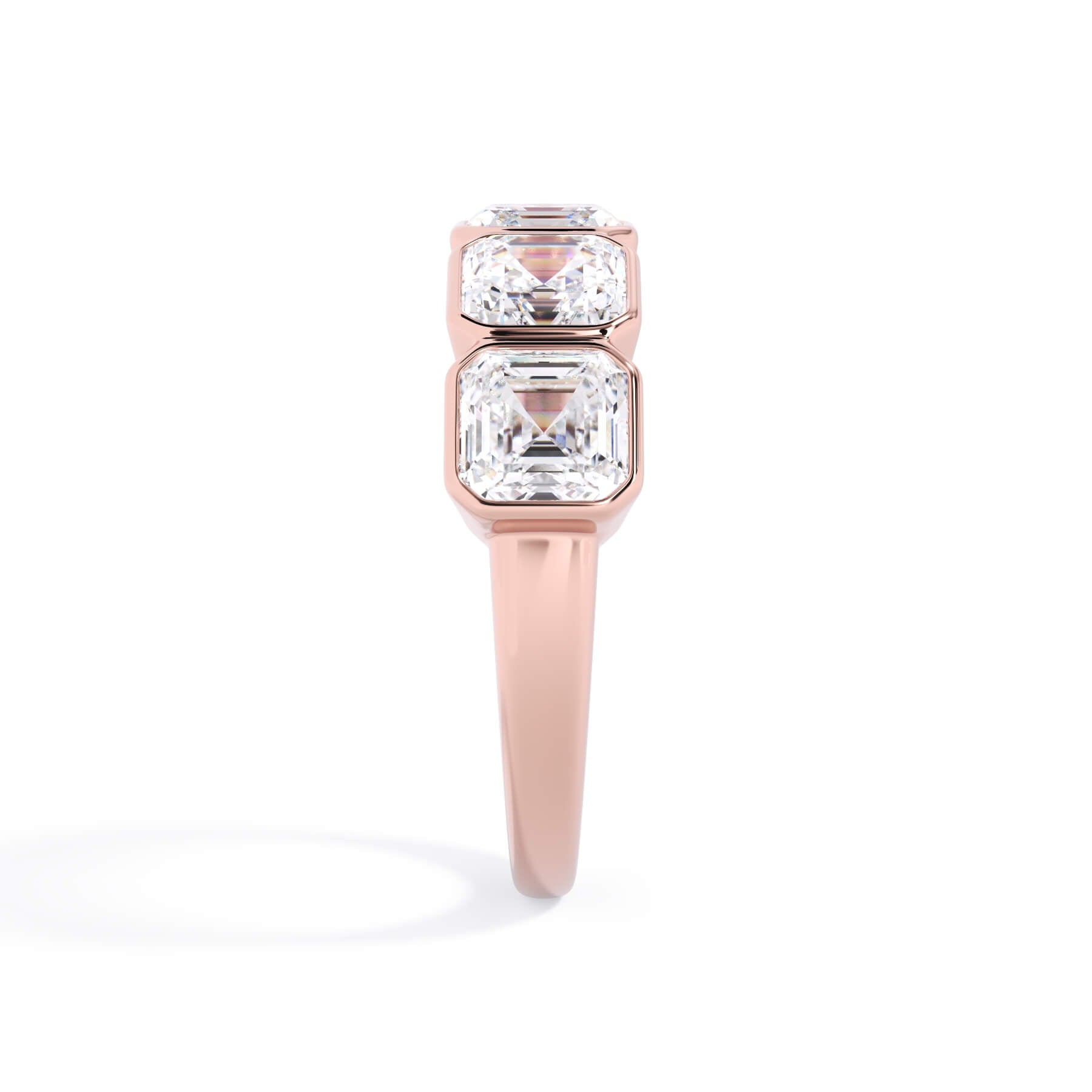 A picture of a five stone diamond wedding ring with asscher shape diamonds that are bezel set in rose gold on a white background with a side profile view.
