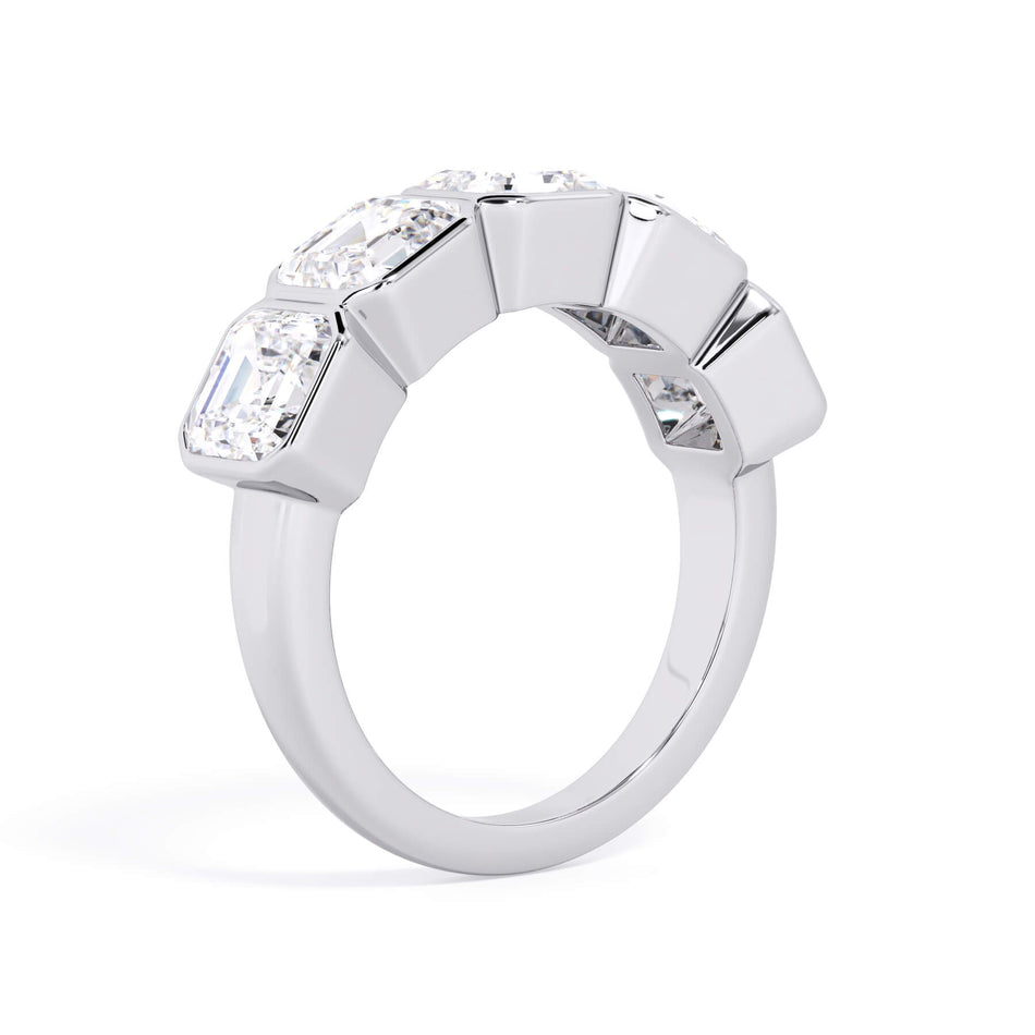 A picture of a five stone diamond wedding ring with asscher shape diamonds that are bezel set in white gold or platinum on a white background with a slightly angled, through the finger view.
