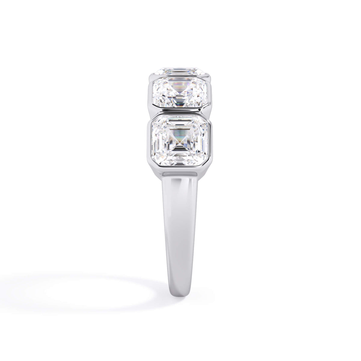 A picture of a five stone diamond wedding ring with asscher shape diamonds that are bezel set in white gold or platinum on a white background with a side profile view.