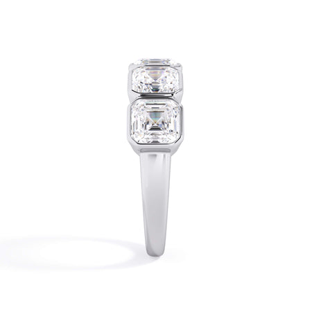 A picture of a five stone diamond wedding ring with asscher shape diamonds that are bezel set in white gold or platinum on a white background with a side profile view.