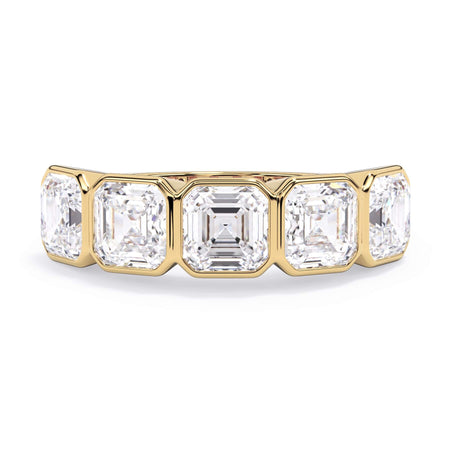 A picture of a five stone diamond wedding ring with asscher shape diamonds that are bezel set in yellow gold on a white background with the ring facing forward, lying down.