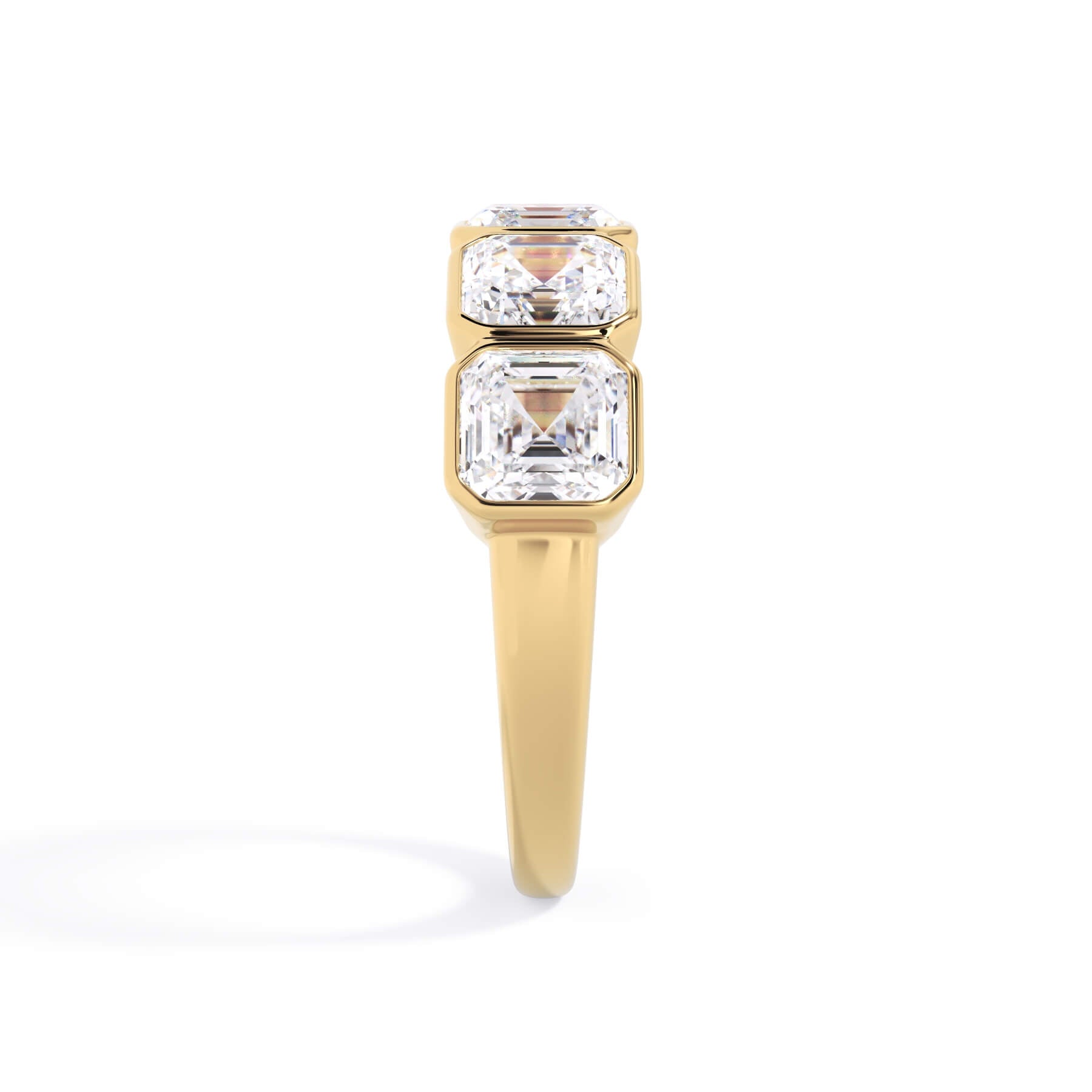A picture of a five stone diamond wedding ring with asscher shape diamonds that are bezel set in yellow gold on a white background with a side profile view.