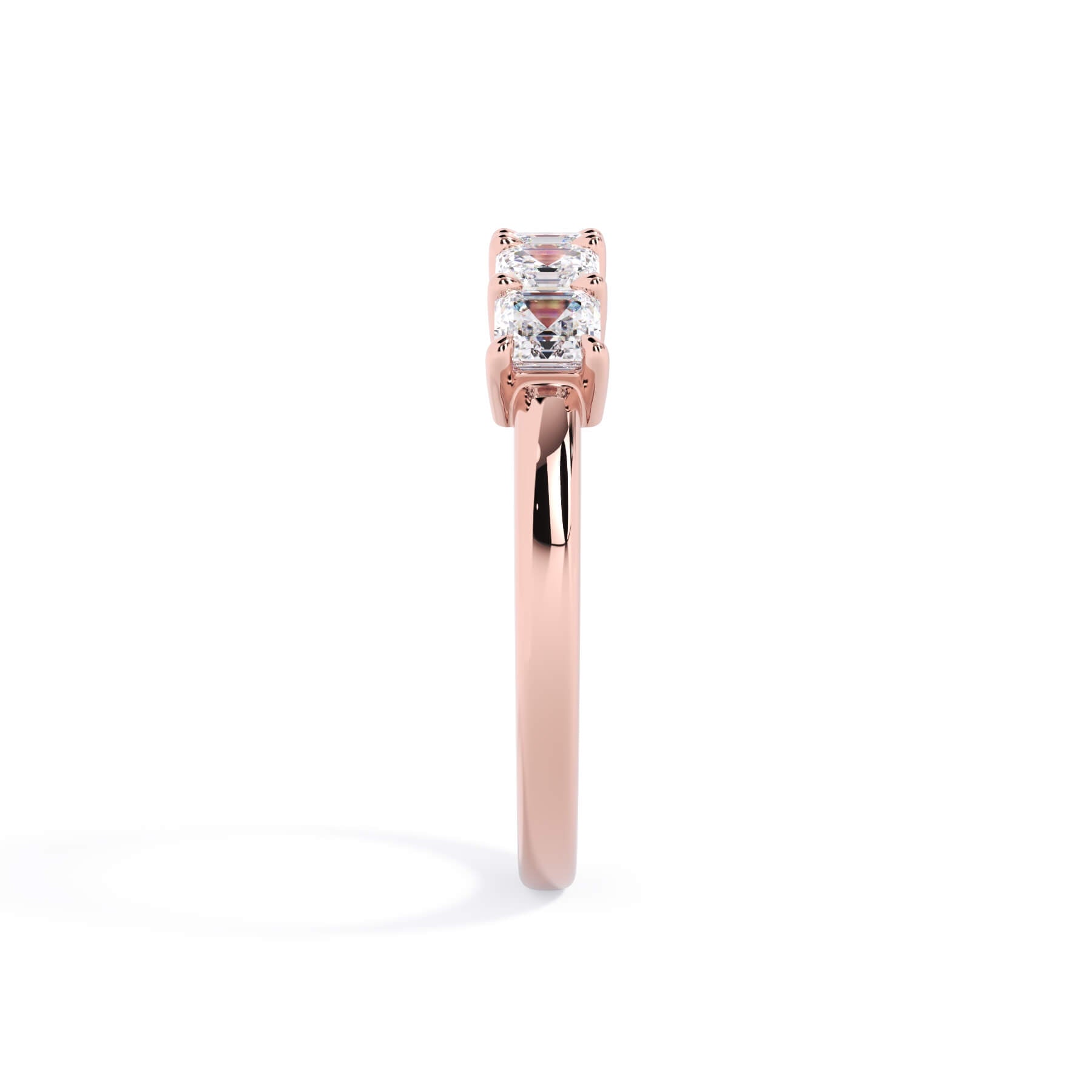 A picture of a five stone diamond wedding ring with asscher shape diamonds that are shared prong set in rose gold on a white background with a side profile view.