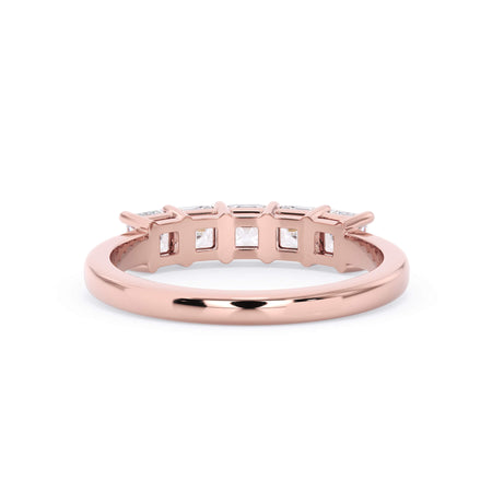 A picture of a five stone diamond wedding ring with asscher shape diamonds that are shared prong set in rose gold on a white background with a view of the underside of the ring.