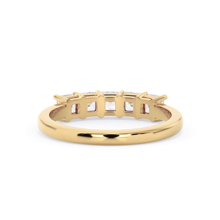 A picture of a five stone diamond wedding ring with asscher shape diamonds that are shared prong set in yellow gold on a white background with a view of the underside of the ring.