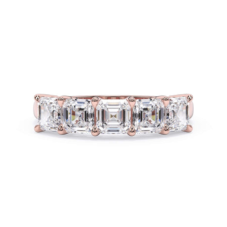 A picture of a five stone diamond wedding ring with asscher shape diamonds that are shared prong set in rose gold on a white background with the ring facing forward, lying down.