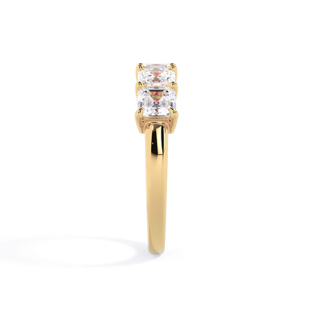 A picture of a five stone diamond wedding ring with asscher shape diamonds that are shared prong set in yellow gold on a white background with a side profile view.