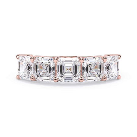 A picture of a five stone diamond wedding ring with asscher shape diamonds that are shared prong set in rose gold on a white background with the ring facing forward, lying down.