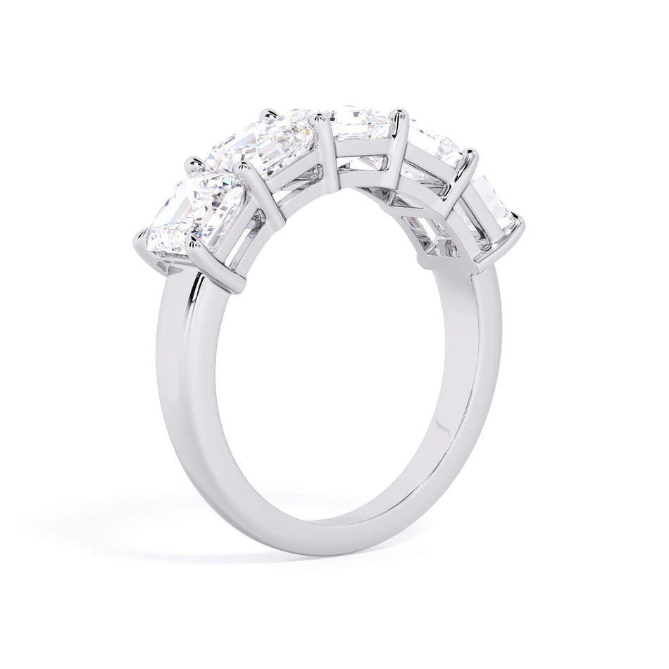 A picture of a five stone diamond wedding ring with asscher shape diamonds that are shared prong set in white gold or platinum on a white background with a slightly angled, through the finger view.