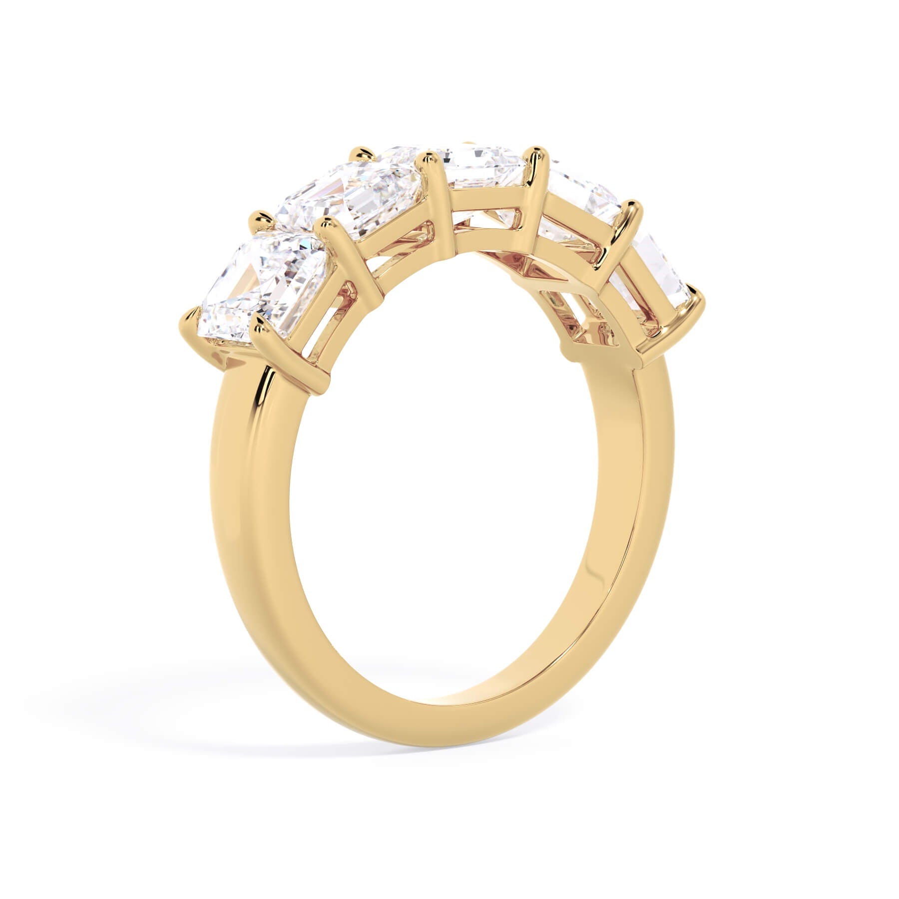 A picture of a five stone diamond wedding ring with asscher shape diamonds that are shared prong set in yellow gold on a white background with a slightly angled, through the finger view.