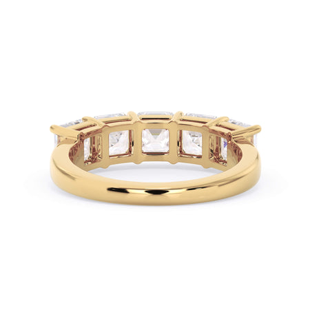 A picture of a five stone diamond wedding ring with asscher shape diamonds that are shared prong set in yellow gold on a white background with a view of the underside of the ring.