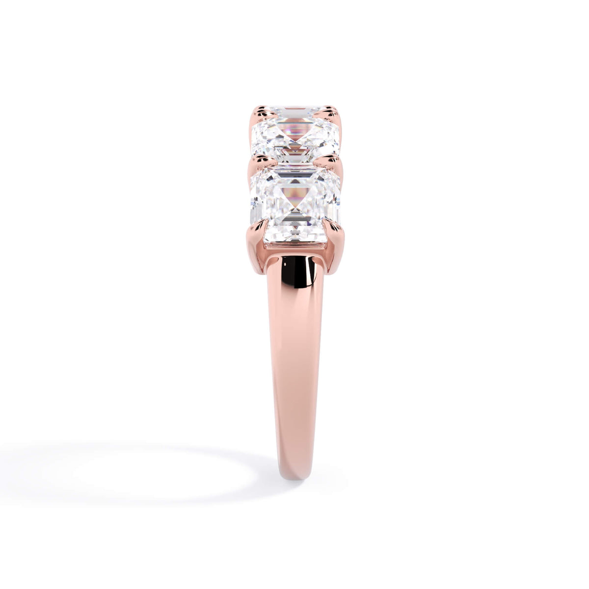 A picture of a five stone diamond wedding ring with asscher shape diamonds that are shared prong set in rose gold on a white background with a side profile view.