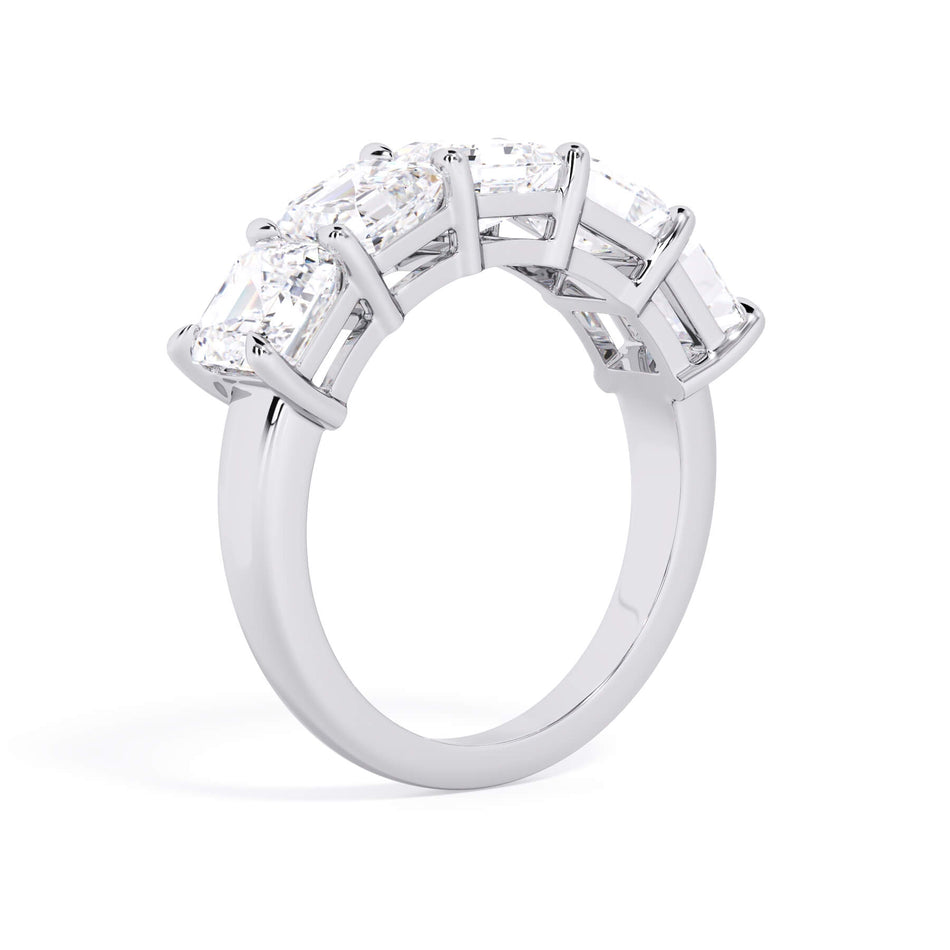 A picture of a five stone diamond wedding ring with asscher shape diamonds that are shared prong set in white gold or platinum on a white background with a slightly angled, through the finger view.