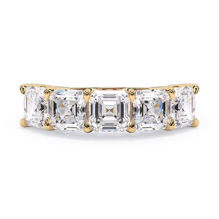 A picture of a five stone diamond wedding ring with asscher shape diamonds that are shared prong set in yellow gold on a white background with the ring facing forward, lying down.