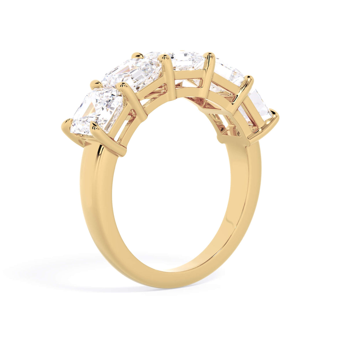 A picture of a five stone diamond wedding ring with asscher shape diamonds that are shared prong set in yellow gold on a white background with a slightly angled, through the finger view.