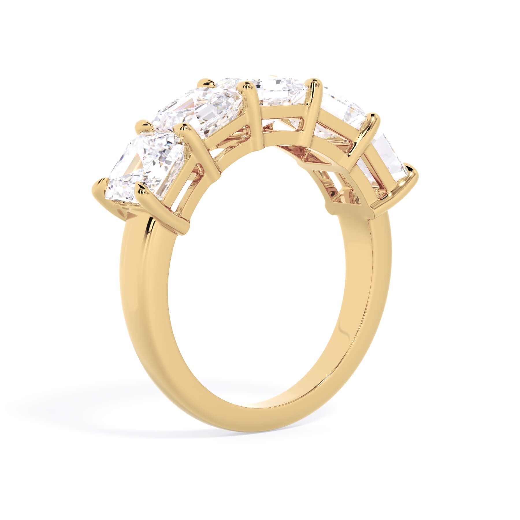 A picture of a five stone diamond wedding ring with asscher shape diamonds that are shared prong set in yellow gold on a white background with a slightly angled, through the finger view.