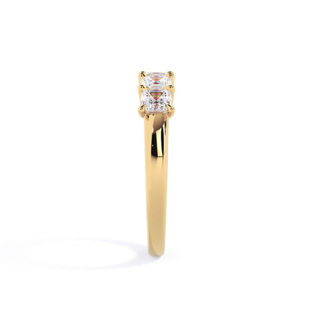 A picture of a five stone diamond wedding ring with asscher shape diamonds that are u prong set in yellow gold on a white background with a side profile view.