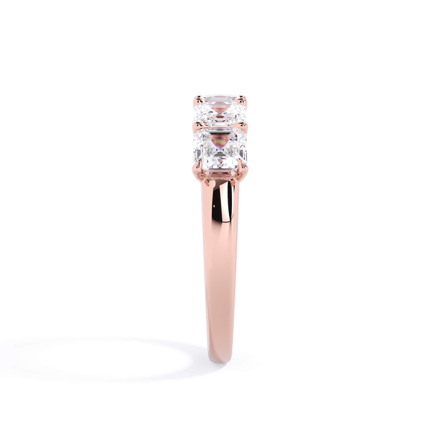 A picture of a five stone diamond wedding ring with asscher shape diamonds that are u prong set in rose gold on a white background with a side profile view.