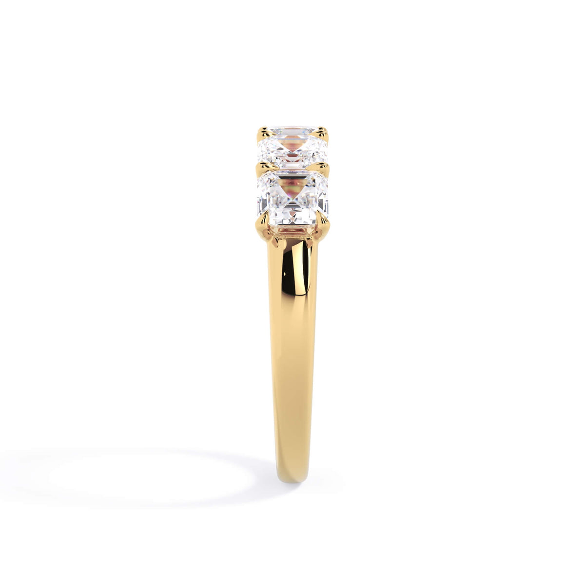 A picture of a five stone diamond wedding ring with asscher shape diamonds that are u prong set in yellow gold on a white background with a side profile view.