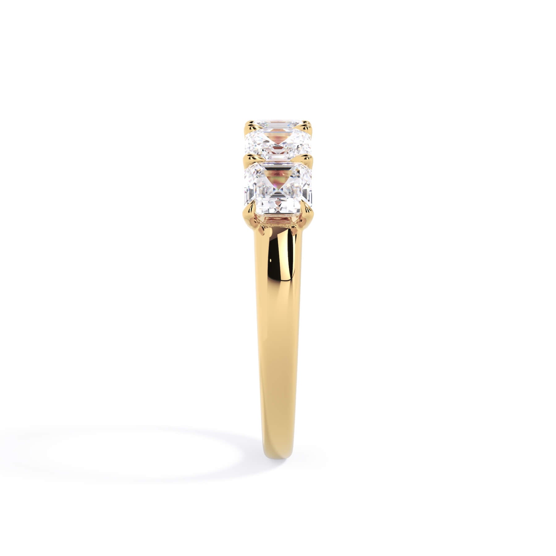 A picture of a five stone diamond wedding ring with asscher shape diamonds that are u prong set in yellow gold on a white background with a side profile view.