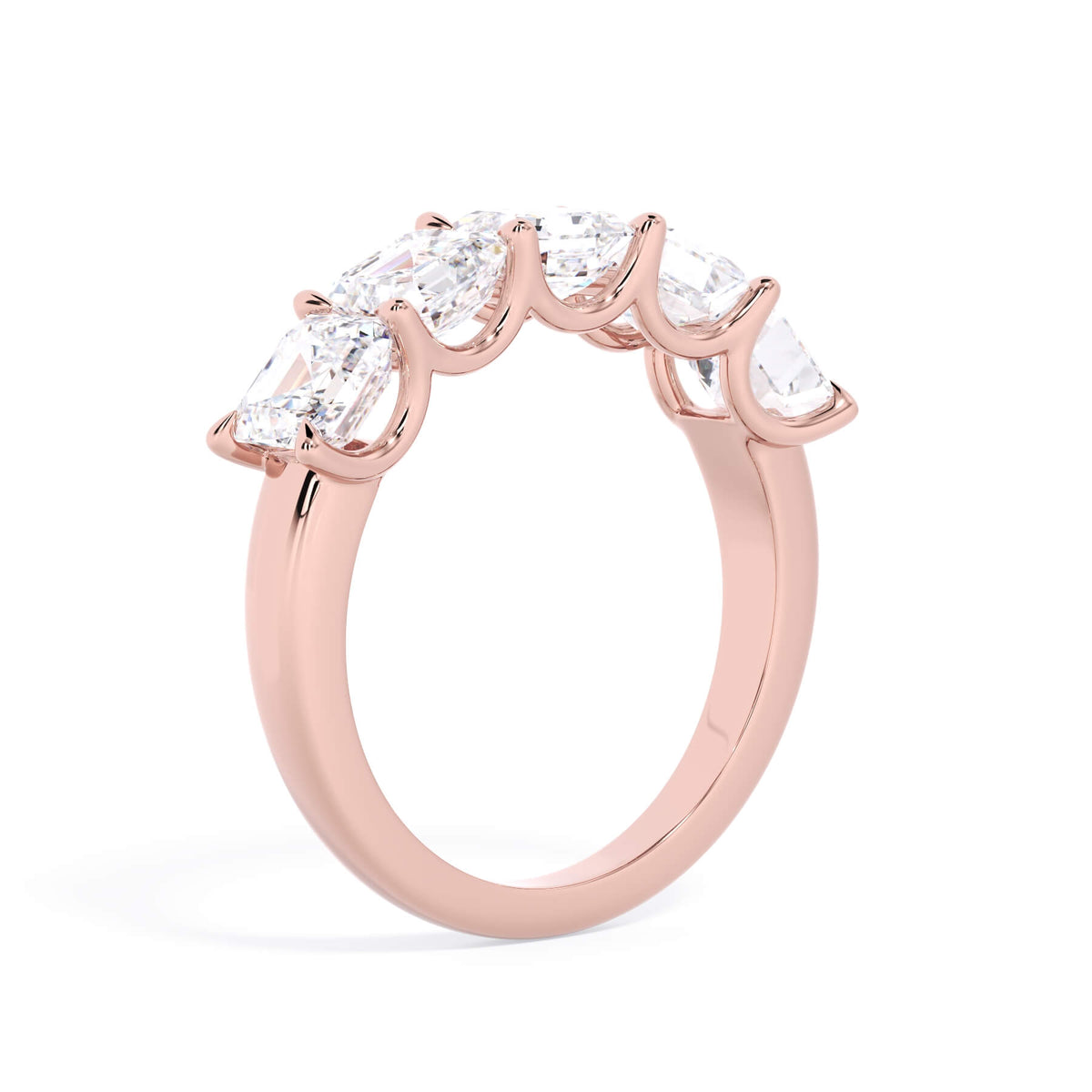 A picture of a five stone diamond wedding ring with asscher shape diamonds that are u prong set in rose gold on a white background with a slightly angled, through the finger view.