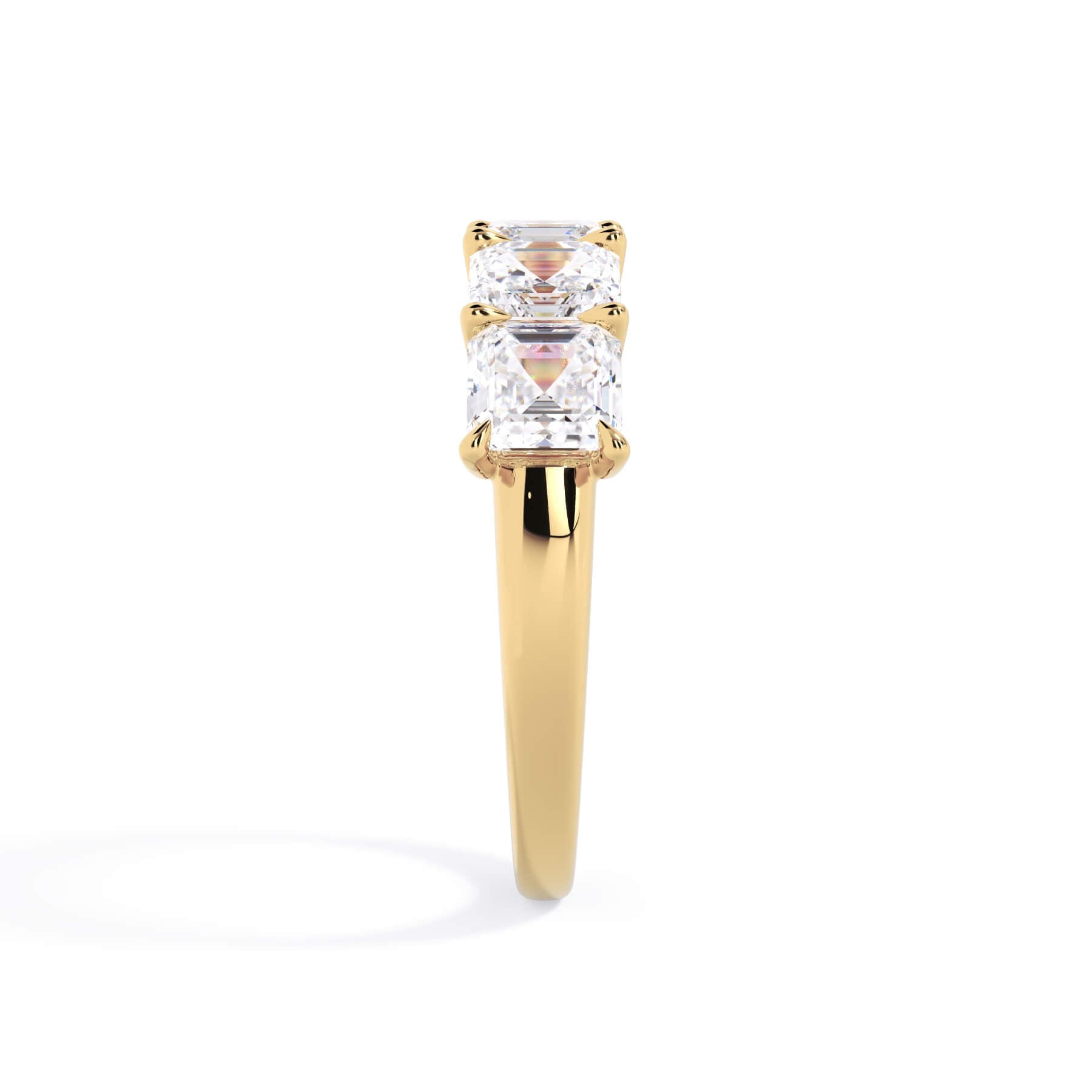 A picture of a five stone diamond wedding ring with asscher shape diamonds that are u prong set in yellow gold on a white background with a side profile view.