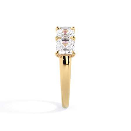 A picture of a five stone diamond wedding ring with asscher shape diamonds that are u prong set in yellow gold on a white background with a side profile view.