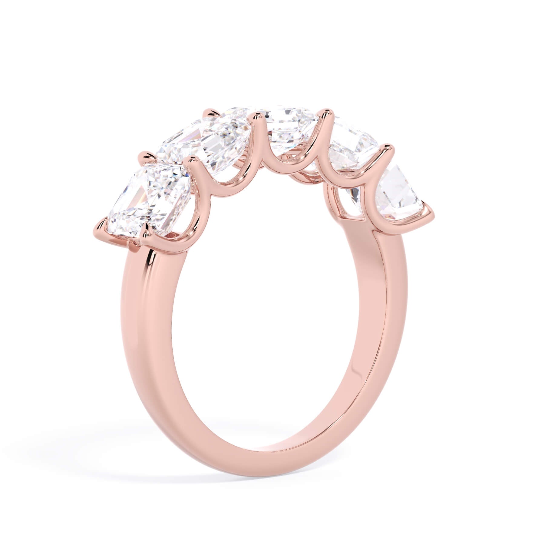 A picture of a five stone diamond wedding ring with asscher shape diamonds that are u prong set in rose gold on a white background with a slightly angled, through the finger view.