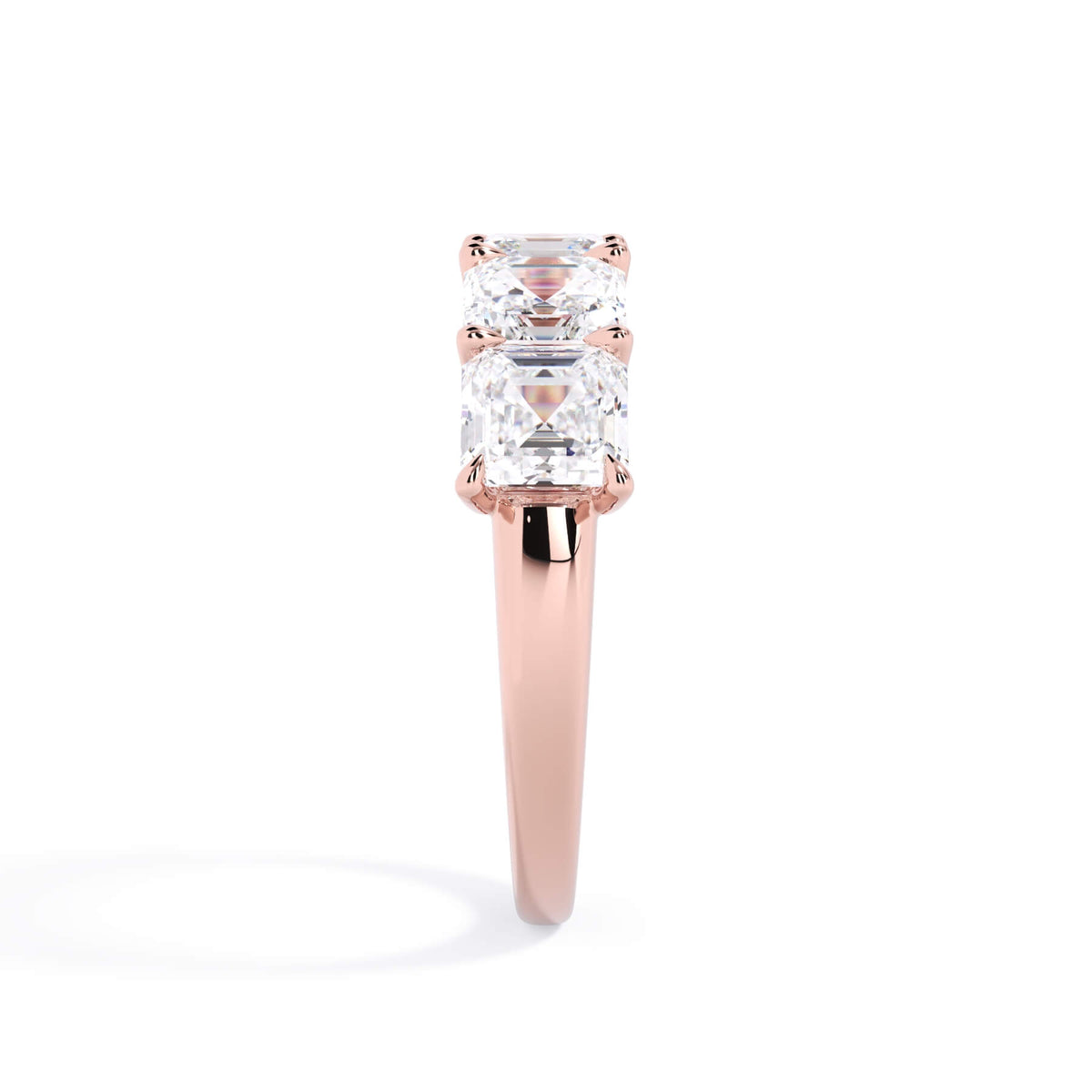 A picture of a five stone diamond wedding ring with asscher shape diamonds that are u prong set in rose gold on a white background with a side profile view.