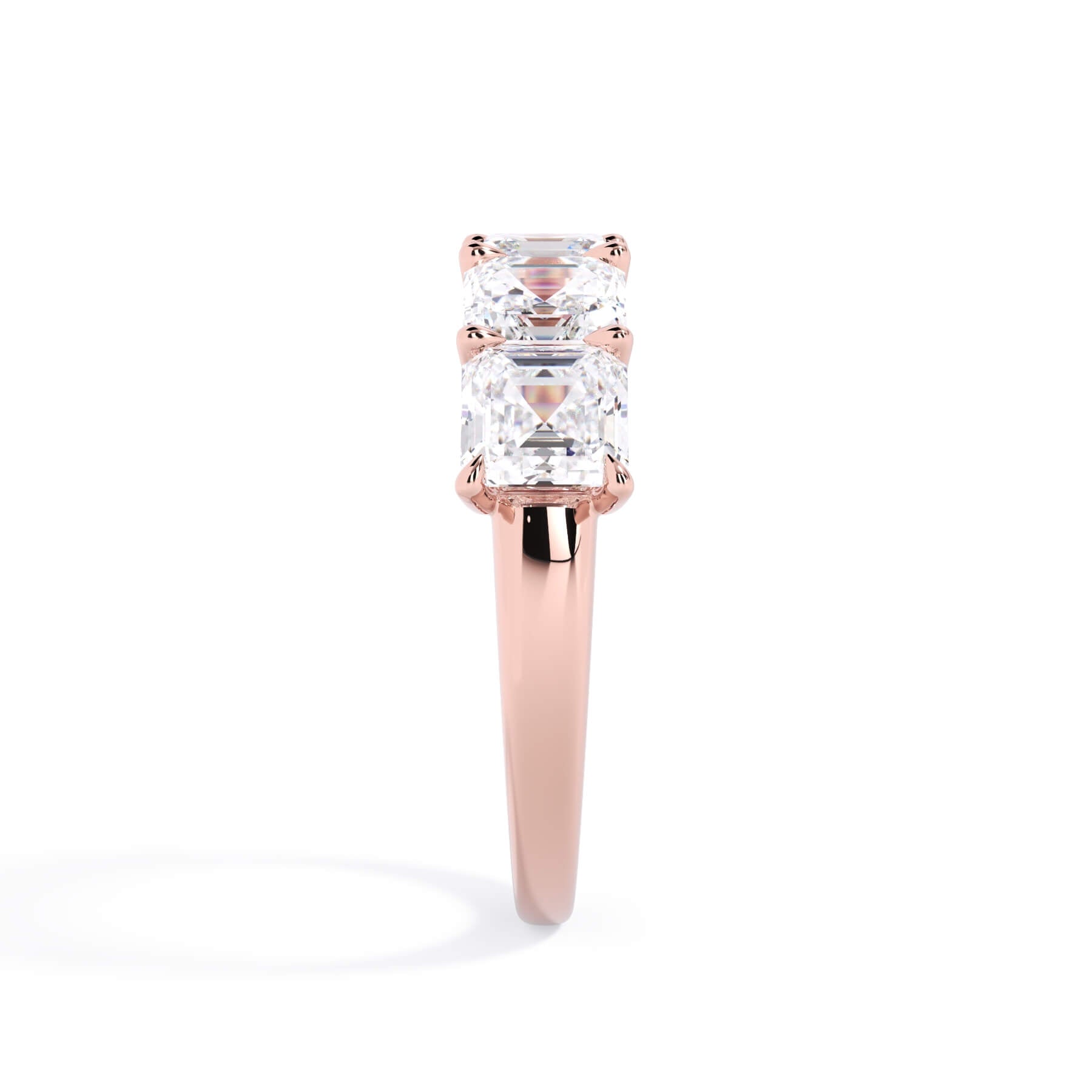 A picture of a five stone diamond wedding ring with asscher shape diamonds that are u prong set in rose gold on a white background with a side profile view.