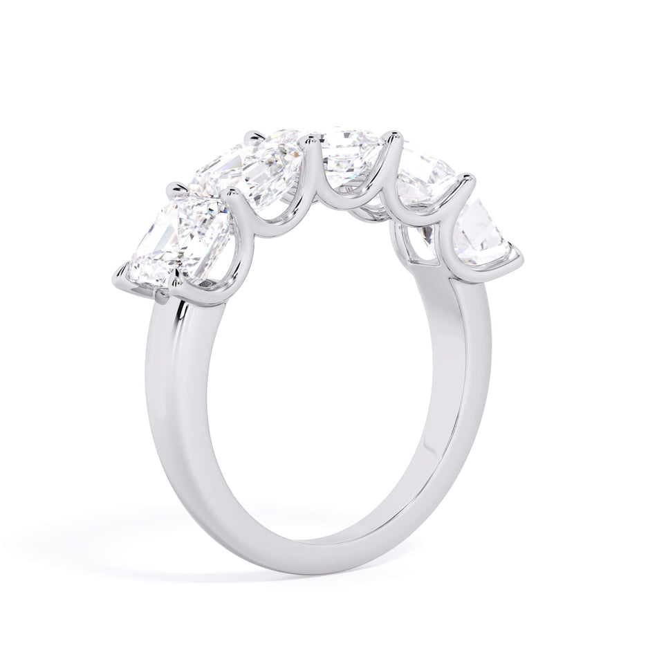 A picture of a five stone diamond wedding ring with asscher shape diamonds that are u prong set in white gold or platinum on a white background with a slightly angled, through the finger view.