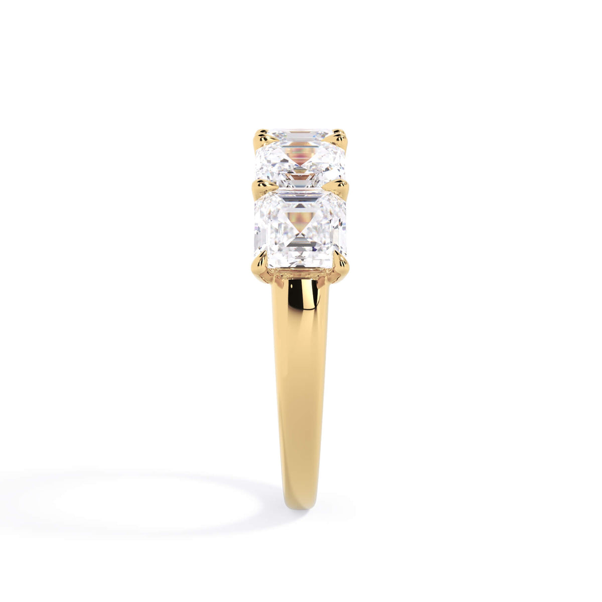 A picture of a five stone diamond wedding ring with asscher shape diamonds that are u prong set in yellow gold on a white background with a side profile view.