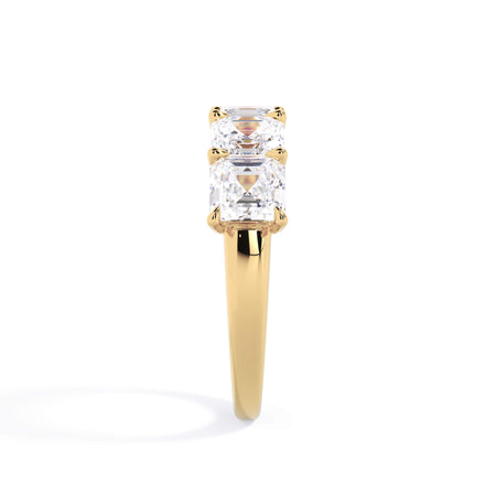 A picture of a five stone diamond wedding ring with asscher shape diamonds that are u prong set in yellow gold on a white background with a side profile view.
