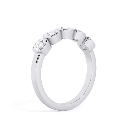 A picture of a five stone diamond wedding ring with cushion shape diamonds that are bezel set in white gold or platinum on a white background with a slightly angled, through the finger view.