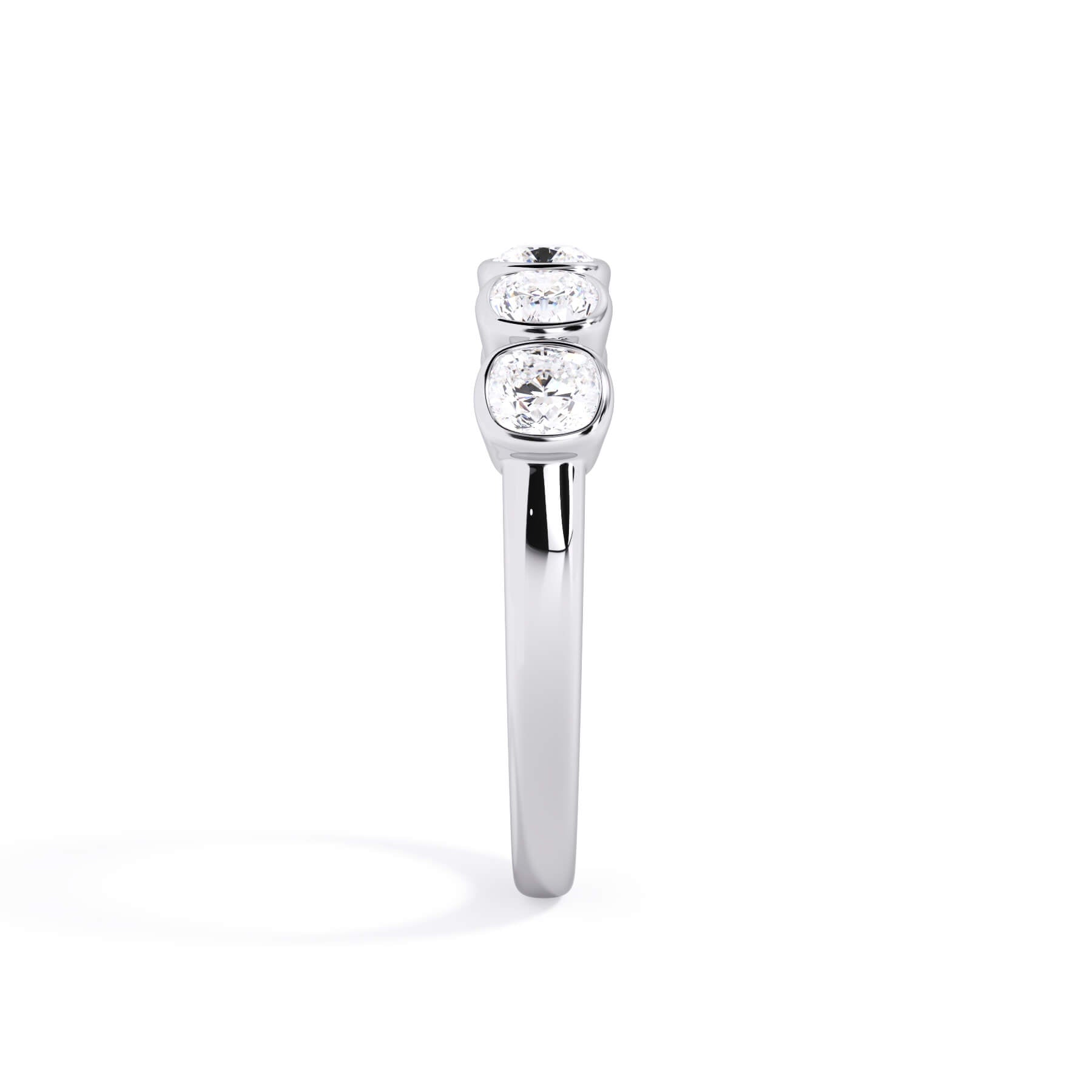 A picture of a five stone diamond wedding ring with cushion shape diamonds that are bezel set in white gold or platinum on a white background with a side profile view.