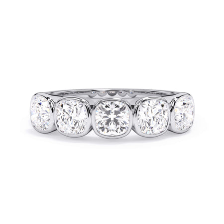 A picture of a five stone diamond wedding ring with cushion shape diamonds that are bezel set in white gold or platinum on a white background with the ring facing forward, lying down.