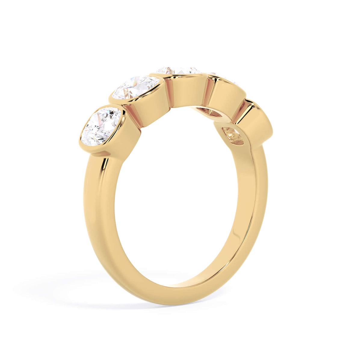 A picture of a five stone diamond wedding ring with cushion shape diamonds that are bezel set in yellow gold on a white background with a slightly angled, through the finger view.