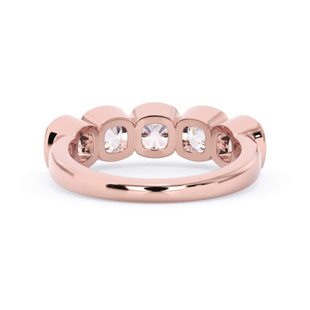 A picture of a five stone diamond wedding ring with cushion shape diamonds that are bezel set in rose gold on a white background with a view of the underside of the ring.
