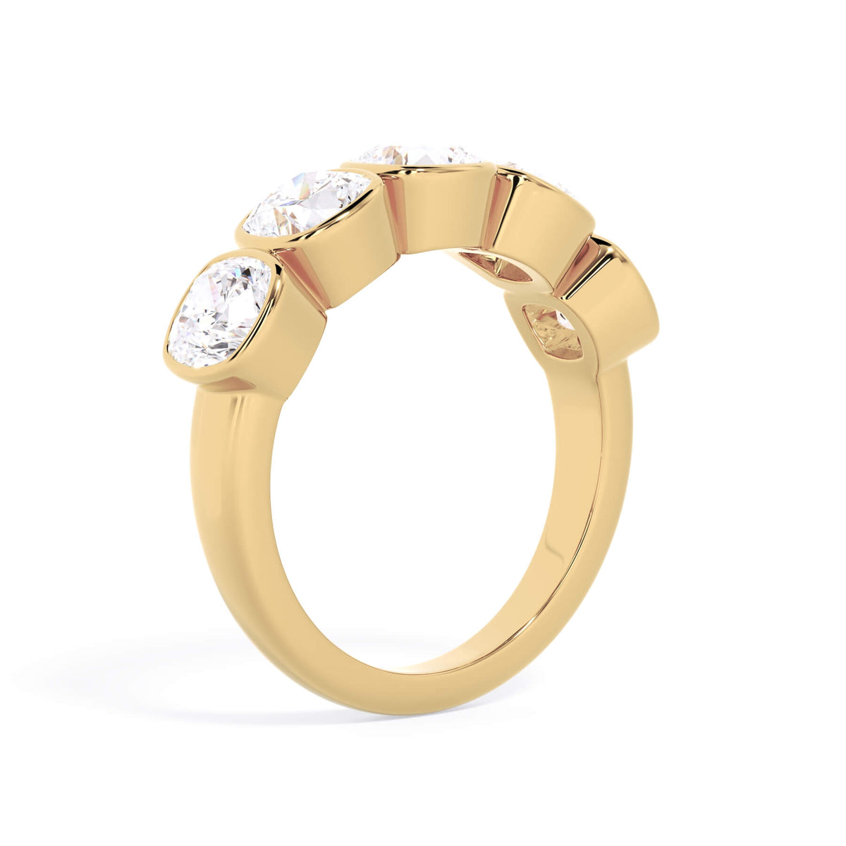 A picture of a five stone diamond wedding ring with cushion shape diamonds that are bezel set in yellow gold on a white background with a slightly angled, through the finger view.