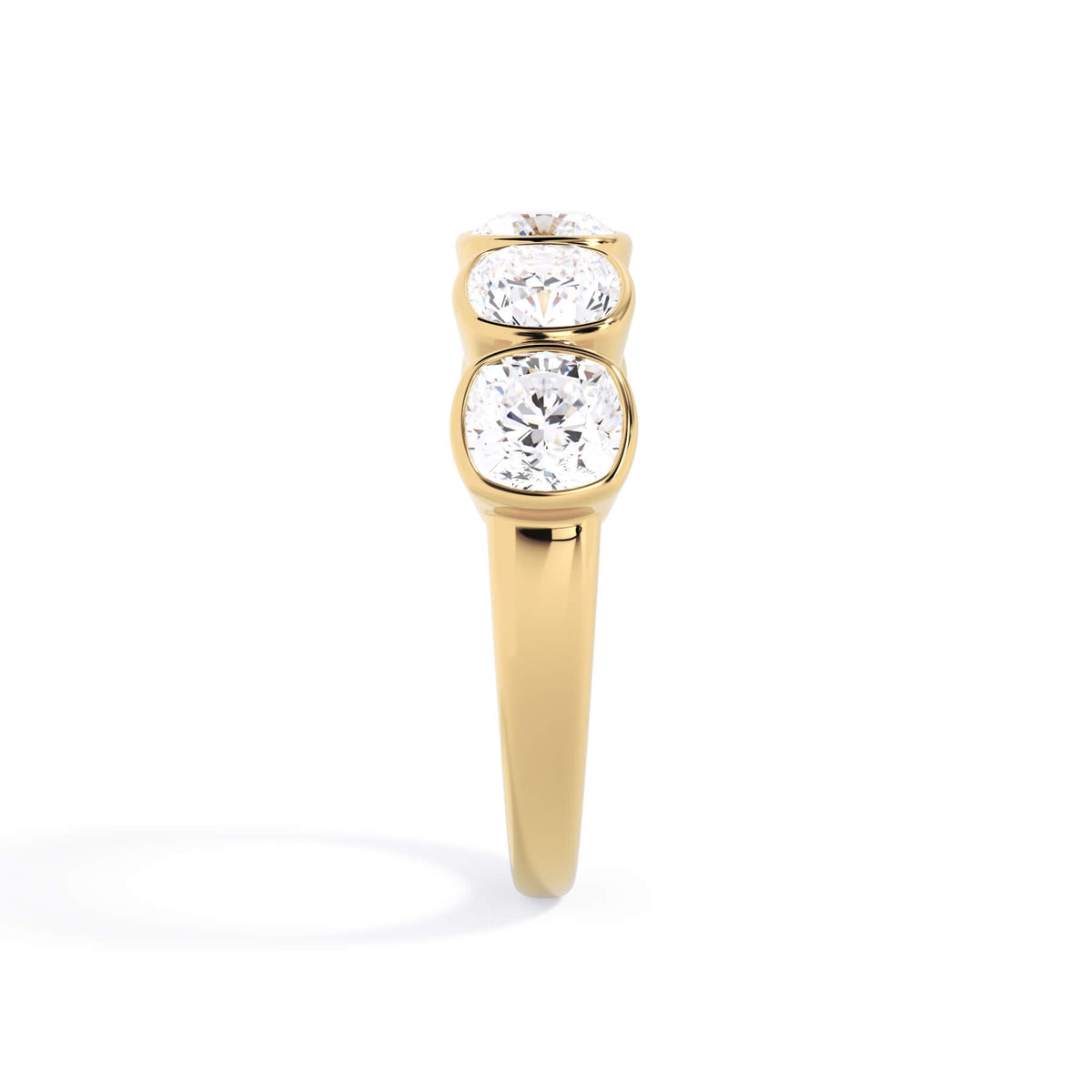 A picture of a five stone diamond wedding ring with cushion shape diamonds that are bezel set in yellow gold on a white background with a side profile view.